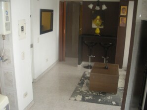 A hallway with a white refrigerator, a mirror, and a wooden door.