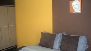 Un dormitorio con cama, almohadas y armario.