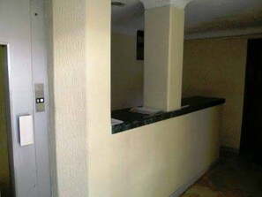 A reception desk with a counter and a door to the left. - Apartamento Santa Barbara Unicentro (Bogotá)