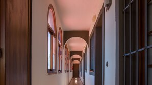 A long, narrow hallway with arched windows and a tiled floor. - Hostal Don Joaquin Alora (Pizarra)