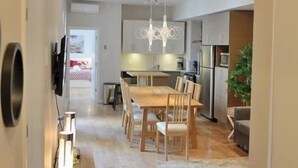 Eine moderne Küche mit Essbereich, Holzboden und einer Pendelleuchte.