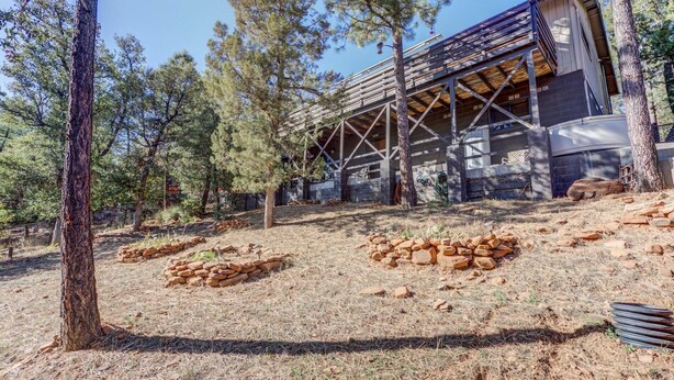 A rustic cabin with a wooden deck and a metal roof structure.