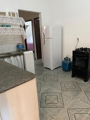 A kitchen with a refrigerator, a washing machine, and a water heater.