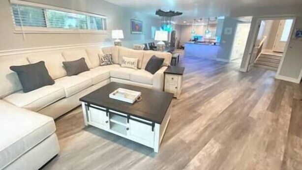 A spacious living room with a sectional sofa, a coffee table, and a ceiling fan.