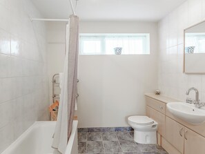 A bathroom with a bathtub, toilet, and sink. - Lovely single-storey cottage with garden in a quiet rural location. (Hassocks)