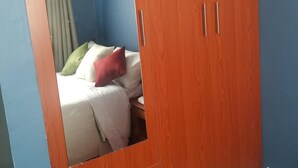 A bedroom with a bed, pillows, and a wardrobe. - The Rhine Guest House-Eldoret (Eldoret)