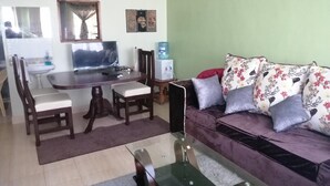 A living room with a dining table, chairs, a sofa, and a TV. - The Rhine Guest House-Eldoret (Eldoret)