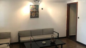 A modern living room with a sofa, two armchairs, a coffee table, and a painting on the wall. - Maryland Hotel Kisumu (Kisumu)
