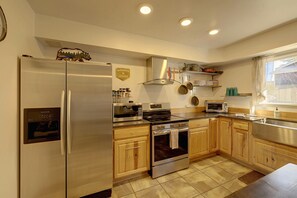 Una cocina moderna con electrodomésticos de acero inoxidable, armarios de madera y un ventanal que proporciona luz natural.