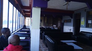 A restaurant with long tables, booths, and a counter. - Millennium Guest House (Narok)