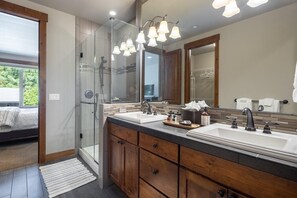 A modern bathroom with a glass shower enclosure, a large mirror, and a double sink vanity. - Game Room, Hot Tub, Suncadia Pool Access (Cle Elum)