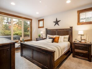 A bedroom with a large bed, a star decoration on the wall, and a view of the outdoors through a window. - Game Room, Hot Tub, Suncadia Pool Access (Cle Elum)