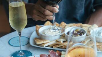 A table with a charcuterie board, wine glasses, and a person holding a wine glass.