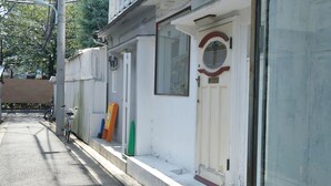 Uma rua estreita com uma fileira de edifícios brancos, uma bicicleta e um cone verde.