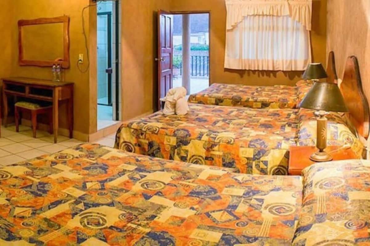 A room with two beds, a desk, and a chair.
