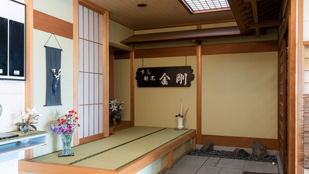 Une pièce de style japonais traditionnel, avec un sol recouvert de tatamis, un banc bas en bois et un paravent shoji.