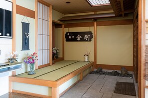 A traditional Japanese room with tatami flooring, a low wooden bench, and a shoji screen. - Tabist Business Hotel Kurama Hikone (Toyosato)