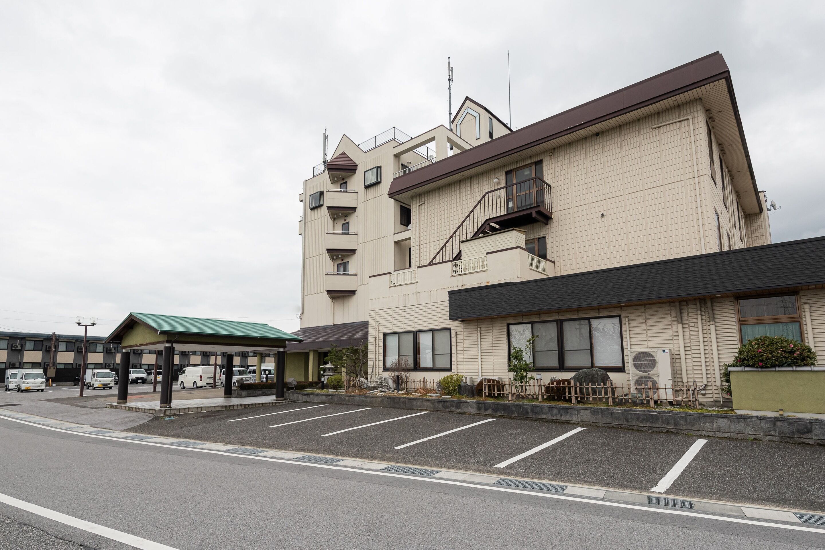 A multi-story hotel with a parking lot in front.