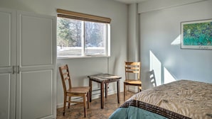 A bedroom with a bed, two wooden chairs, a small table, and a window with blinds. - Homer Hideaway on Fritz Creek! Families Welcome (Homer)