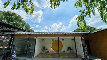 A traditional Japanese building with a large circular window, wooden flooring, and a stone pathway leading to it.