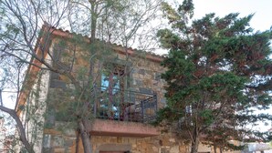 A stone building with a balcony, surrounded by trees. - Lively Lofts by The Varos Residences (Lemnos)