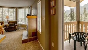 Una habitación con chimenea, un sofá, una mesa de comedor y vistas al exterior.