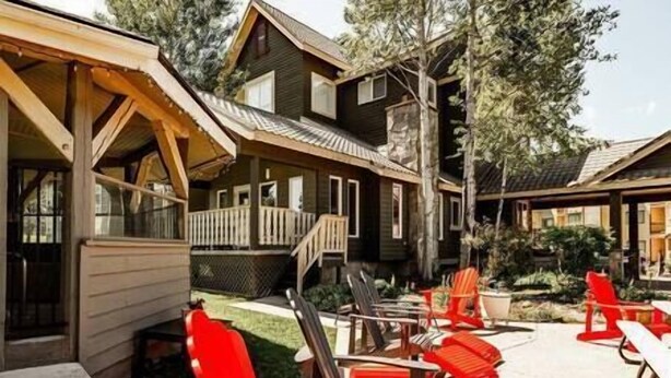 Un edificio de estilo cabaña de madera con porche y zona de estar al aire libre.