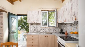 Cozinha com armários de madeira, uma janela e painel de azulejos.