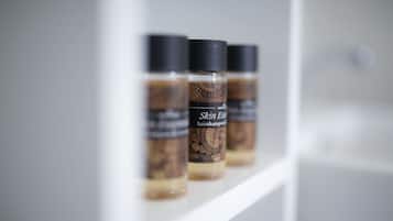 Drei Flaschen Skin Essence Haarschampoo auf einem weißen Regal.