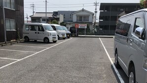 A parking lot with several white vans parked in designated spaces. - Arks Inn Omori (Ube)