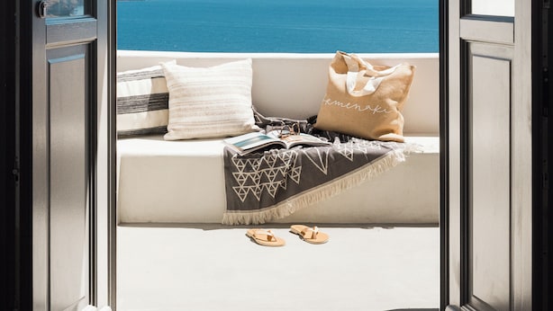 An open door leading to a balcony with a view of the sea and distant hills. - Armenaki -  Adults Only (Santorini)