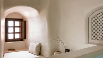 Una habitación con piscina, ventana con contraventanas, cama y estante en la pared.