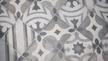 A close-up of a patterned tile floor with a geometric design.