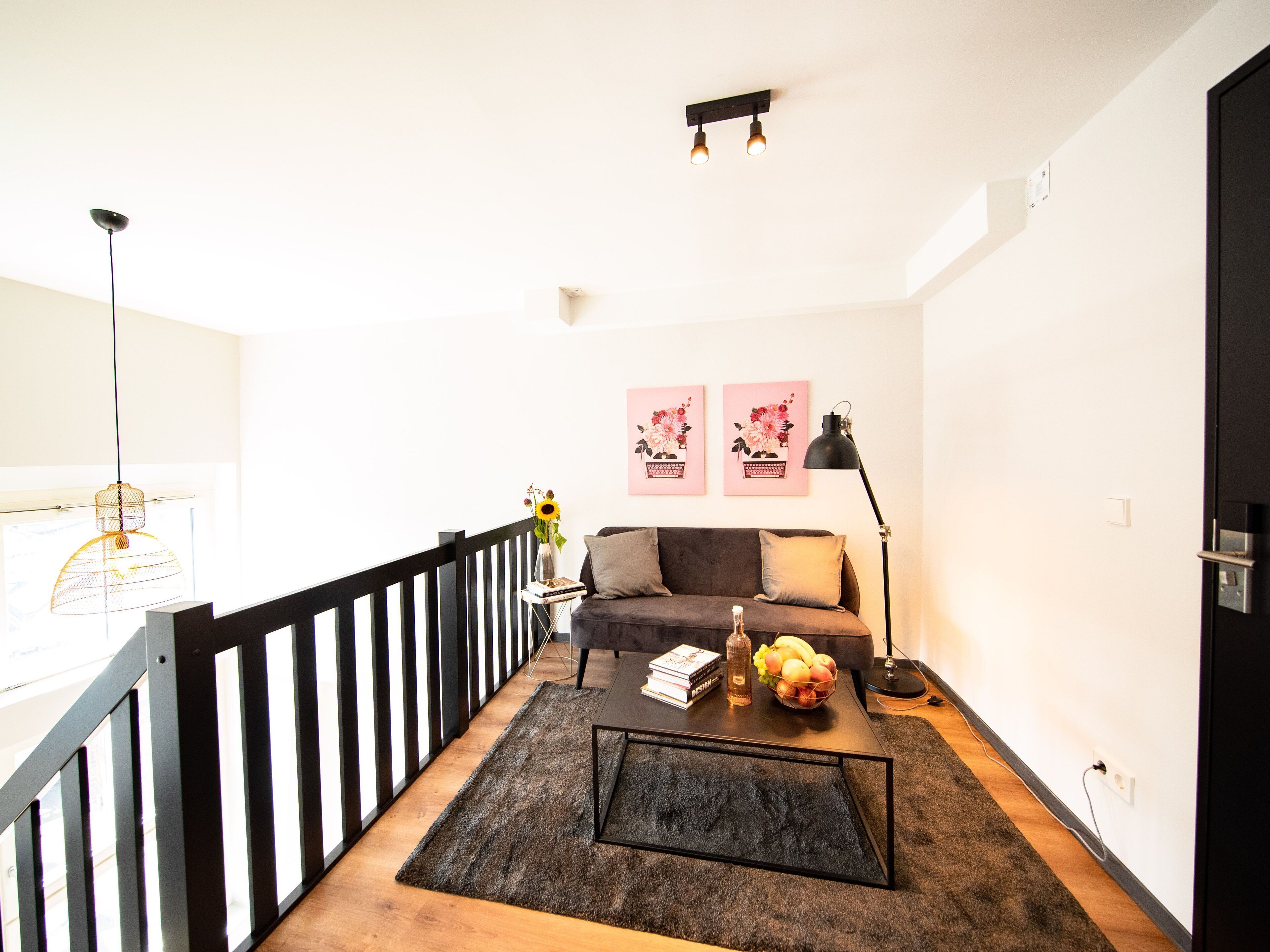 A modern living room with a sofa, coffee table, and artwork on the wall.