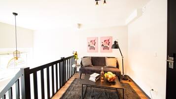 A modern living room with a sofa, coffee table, and artwork on the wall.