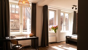 Una habitación con escritorio, silla, radiador y cama.