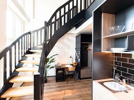 Una cocina moderna con estufa integrada, un lavamanos y una mesa de comedor de madera con sillas.