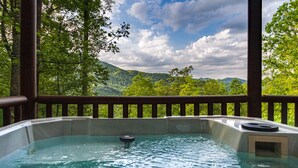 Un jacuzzi con vistas a un bosque y montañas.