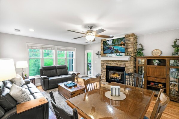 A living room with a fireplace, a television, and a dining area.