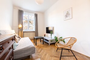 A modern hotel room with a bed, a desk, a chair, a TV, and a window with curtains. - Warsaw Concierge Old Town Square (Warsaw)