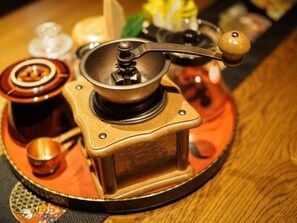Enjoy coffee preparation with a vintage coffee grinder and accompanying accessories.
