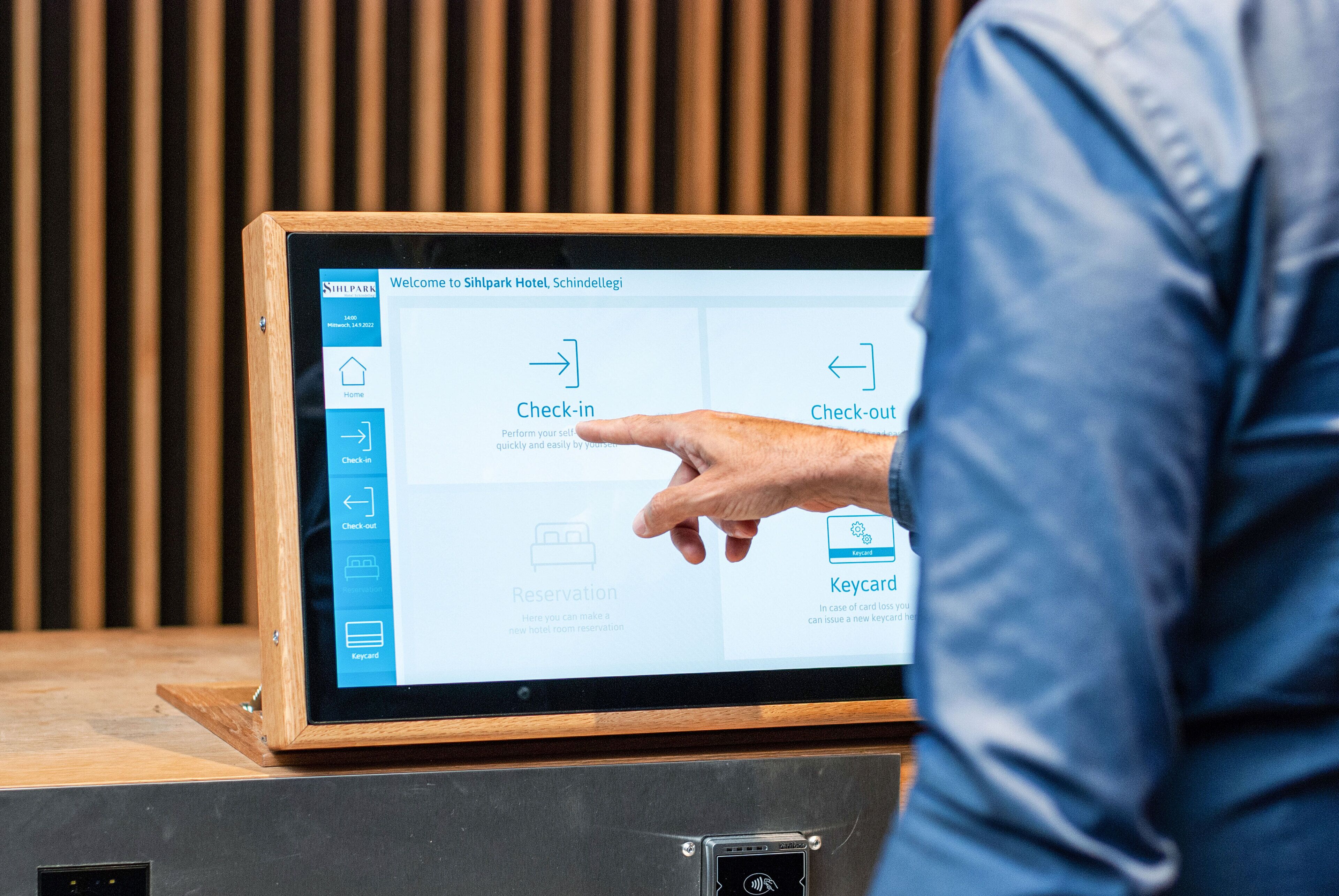 A digital kiosk with options for check-in, check-out, and reservation at a hotel.