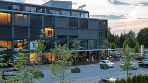 A modern building with multiple levels, large windows, and outdoor seating areas. - Tailormade Hotel SIHLPARK Schindellegi (Feusisberg)