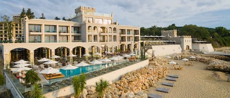 En la playa, sillas reclinables de playa, sombrillas, toallas de playa