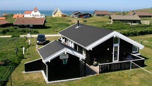 A residential area with houses, a basketball hoop, and a view of the sea. - 4 Star Holiday Home in Hjorring (Hjørring)