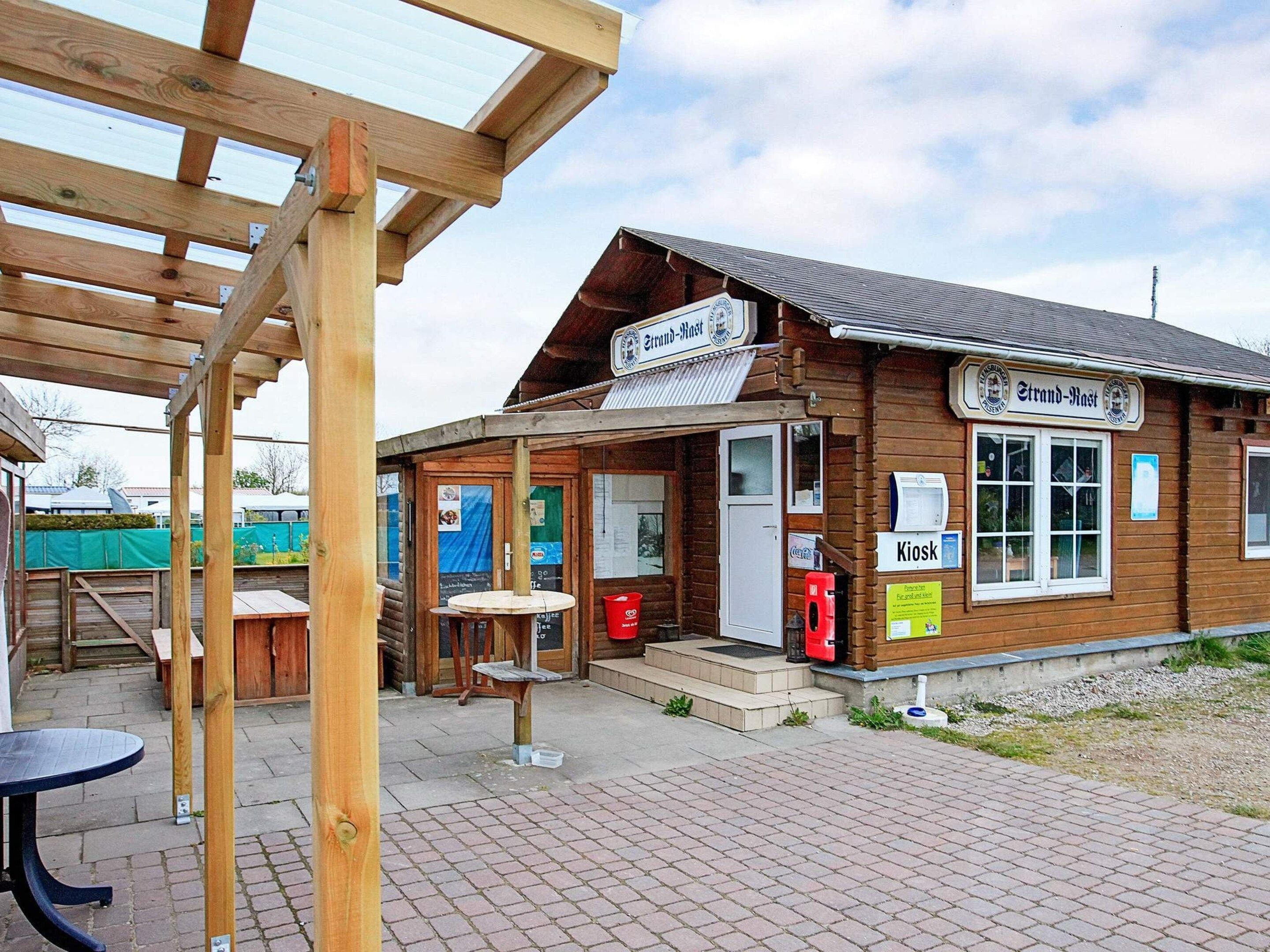 A wooden building with a sign reading 'Strand-Mast' and a 'Kiosk' sign.