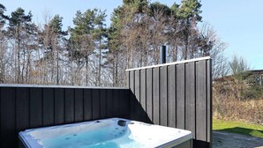 A hot tub on a wooden deck with a wooden fence and trees in the background. - Splendid Holiday Home in Laeso near Museum Court (Læsø)
