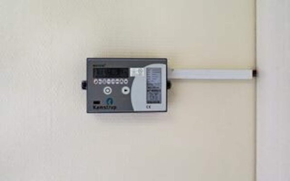 A wall-mounted device with a display screen, buttons, and a cable connected to it. - 4 Star Holiday Home in Lemvig (Lemvig)