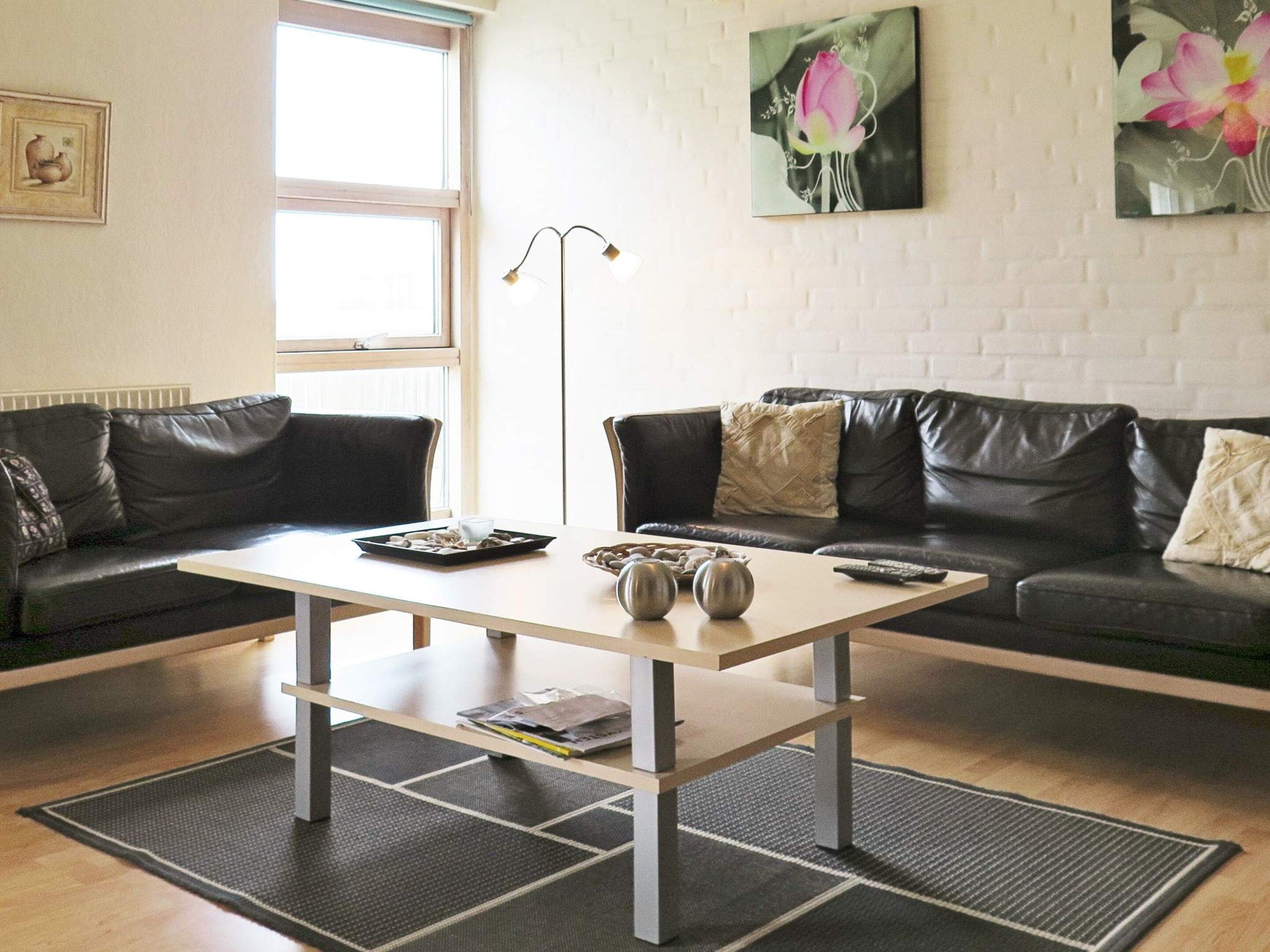A living room with a sofa, a coffee table, and artwork on the wall.