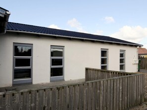A single-story building with a flat roof and a wooden fence in front. - 4 Star Holiday Home in Lemvig (Lemvig)